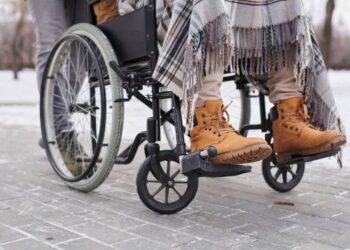 Tânără arestată preventiv pentru că a bătut și tâlhărit un om al străzi, în scaun cu rotile