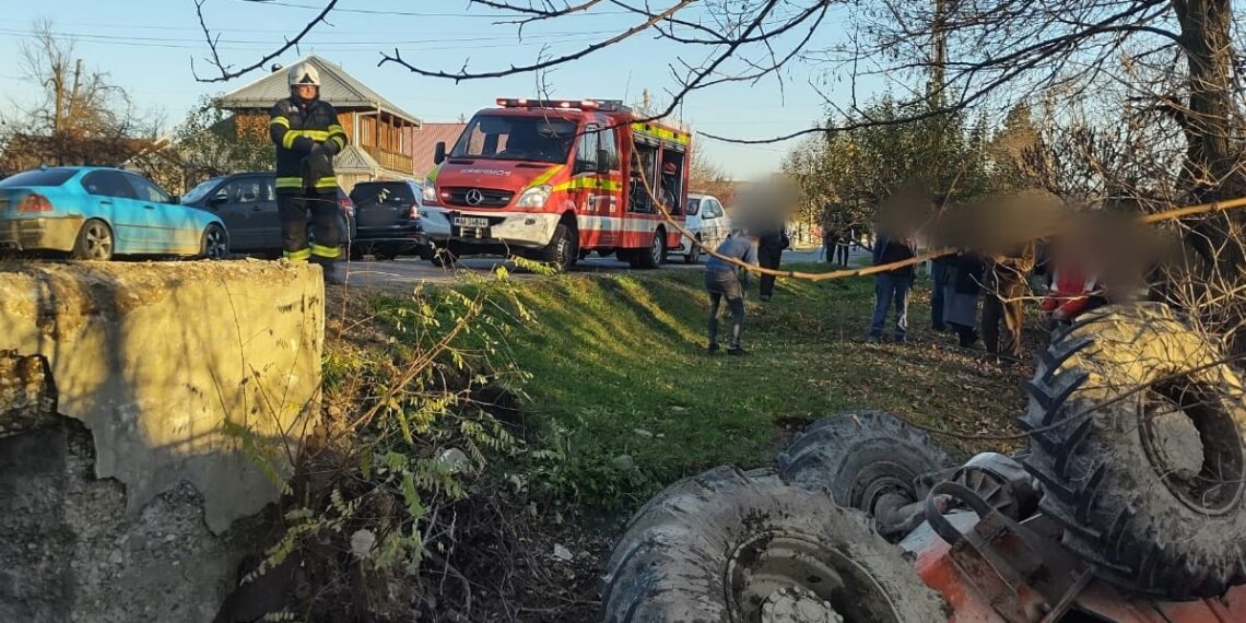 TAF răsturnat în afara unui drum din Râșca. Un bărbat a rămas blocat în interiorul utilajului